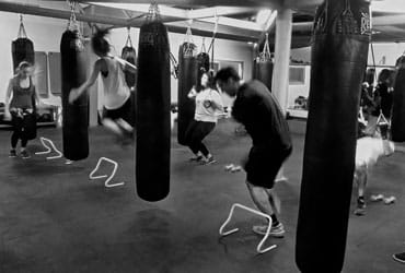 A group of people practicing boxing in a Boxing Gym.
