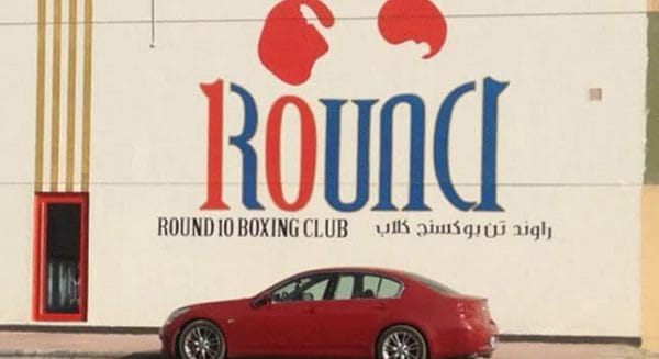 A car is parked in front of a building with the word round on it.