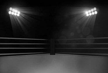 A black and white picture of a boxing ring in a gym.